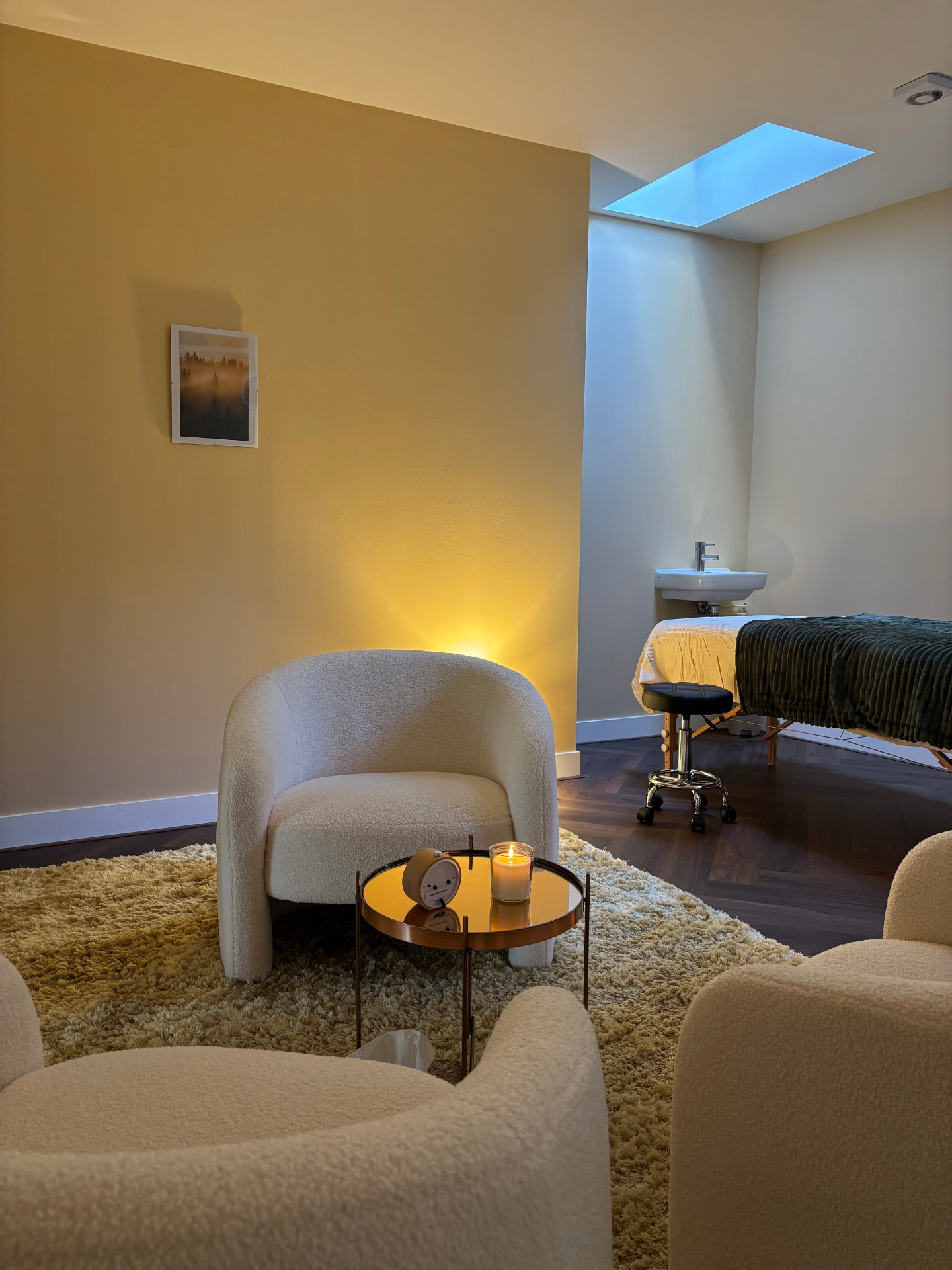 Soft armchair and candle in a warm treatment room